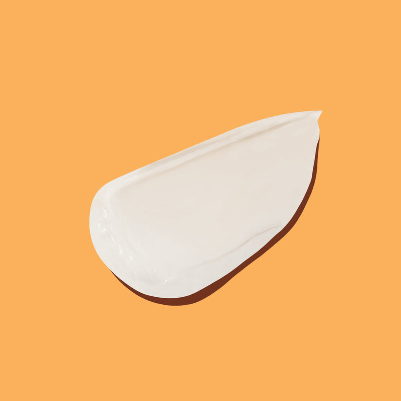 a swatch of the conditioner is neatly laid out on an orange background, the texture is a which white cream.